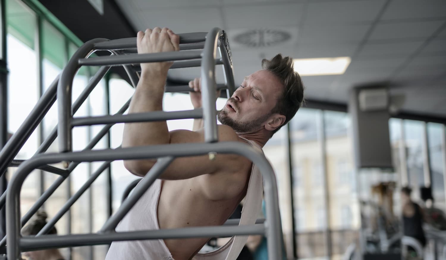 White man doing a pull-up at the gym